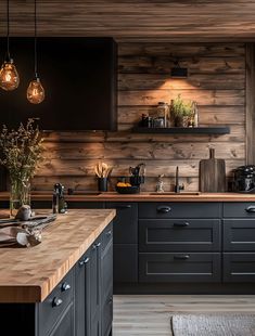 a kitchen with wood paneling and black cabinetry, lights hanging from the ceiling