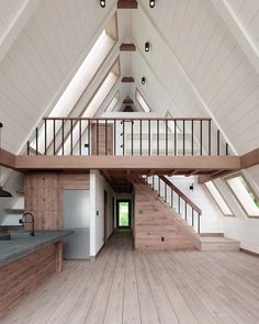 an empty room with wooden floors and white walls is shown in this image, there are stairs leading up to the second floor