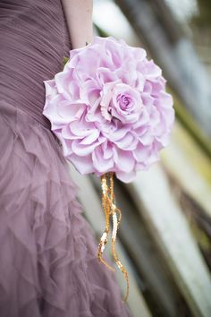 the bride's bouquet is adorned with purple flowers