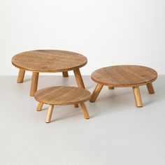 two wooden stools sitting next to each other on top of a white flooring