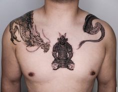 a man with tattoos on his chest has a dragon and demon tattoo on his chest