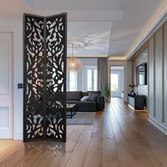 an open room divider in the middle of a living room with wood flooring