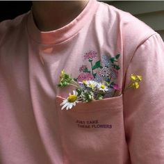 a person wearing a pink shirt with flowers in the pocket