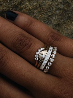 a woman's hand with two rings on her fingers and one ring is gold, the other has white diamonds