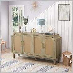 a sideboard with wicker doors and drawers in a room next to a staircase