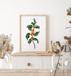 an orange flower is displayed in a frame on a table next to other plants and vases