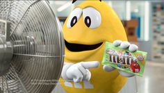 a banana holding a candy bar next to a fan