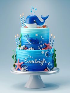 there is a blue cake with a whale on top and candles in the bottom that are lit