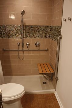 a bathroom with a toilet, shower and bench