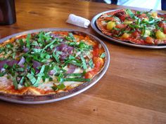 two pizzas sitting on top of metal pans