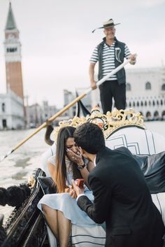 a man and woman on a gondola in venice talking on their cell phones