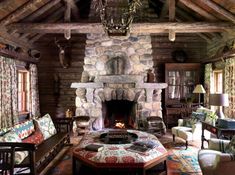 a rustic living room with stone fireplace and wood paneled walls, decorated in floral fabrics