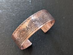 Copper cuff bracelet with Mehndi pattern on the outside and a hammered texture on the inside .  Made from 100% raw copper and is untreated ( no lacquer and no wax are used to seal it )  I like raw copper and love how the patina changes over time . If tat is not your thing I do add a small jewelers cloth to your bracelet so you can shine it up as desired .  You can also use ordinary ketchup to clean your copper ( old trick from cooks that use copper pans to cook ) 3/4 inch wide and 6 inch long wi Mehndi Patterns, Copper Cuff Bracelet, Copper Cuff, Pure Copper, Handmade Bracelets, Cuff Bracelet, Cuff Bracelets, Favorite Jewelry, Copper