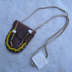 an old purse with some beads on it and a tag attached to the back of it