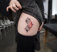 a woman with a tattoo on her thigh that has an image of two squares in it