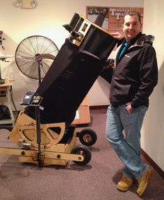 a man standing next to a large black object