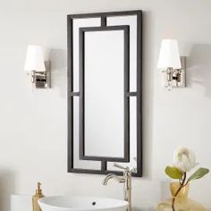 a white sink sitting under a bathroom mirror next to a wall mounted faucet