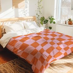 an orange and white checkered comforter on a bed