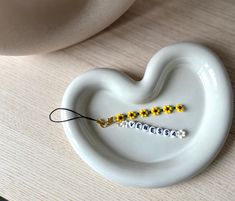 a pair of yellow and white beaded earbuds sitting on top of a white plate