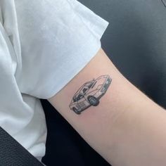 a small tattoo on the arm of a woman's left arm, depicting a camper van