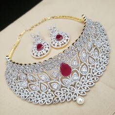 "Handmade Indian Jewelry, best to wear for traditional ceremonies or Indian wedding. This bridal jewelry has ethnic finish. It has very high quality ADs with ruby It is a Bollywood style one gram jewelry. Handmade Indian Jewelry item * Necklace Set is a combo of Necklace & Stud Earrings * Necklace is adjustable with adjustable back chain/ Dori/ Cord * Earring Length: 2\", Earring Width: 1.0\" * Choker : Main design 8 inches. Center 2.5 inches * Gold Color is gold tone which has a bright gold Bollywood Ruby Necklaces With Intricate Design, Ruby Chandbali Necklace With Intricate Design, Bollywood Ruby Necklace With Intricate Design, Bollywood Style Ruby Necklace With Intricate Design, Traditional Bridal Sets With Intricate Design And American Diamond, Diwali Ruby Jewelry Set With Intricate Design, Traditional Bridal Necklace With Intricate Design In American Diamond, Traditional Cubic Zirconia Jewelry Sets For Festivals, Traditional Bridal Necklace With Intricate American Diamond Design