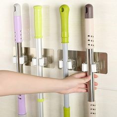 a person is holding onto the handle of a wall mounted toothbrush dispenser