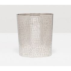 a silver vase sitting on top of a white table