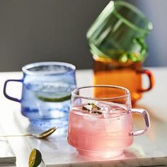 three different colored glasses sitting on top of a table