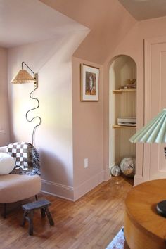 a living room filled with furniture and a lamp on top of a hard wood floor