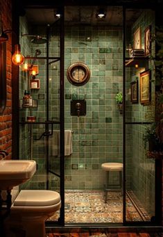 a bathroom with green tiles and a white toilet next to a walk - in shower