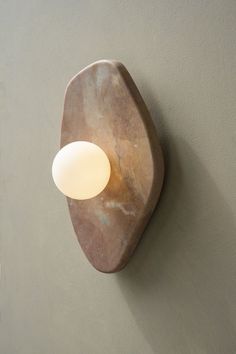 a light that is on the wall next to a white wall mounted fixture with a marbled surface