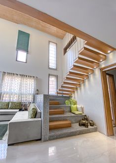 a living room filled with lots of furniture under a stair case