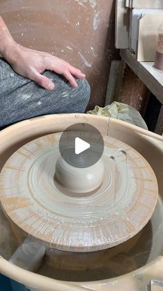 a man sitting on top of a pottery wheel