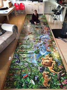 a woman is sitting on the floor in front of a large rug with animals and plants