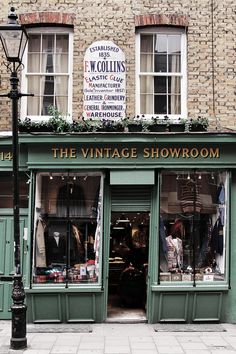 the vintage showroom is located in an old brick building with green shutters and windows