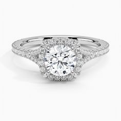 a white gold engagement ring with an oval center surrounded by round brilliant cut diamond halos