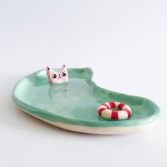 a green plate with a cat in it and a life preserver on the edge