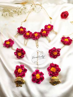 the necklace is adorned with red flowers and gold bells, along with other jewelry pieces