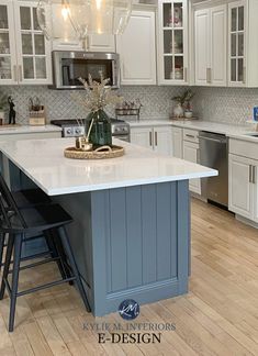 a kitchen with white cabinets and blue island