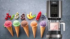 five ice cream cones lined up next to an espresso machine with fruit on top