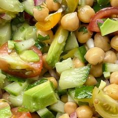 a salad with chickpeas, tomatoes, cucumbers and lettuce