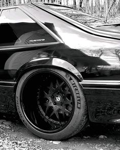 a black and white photo of a car parked in the woods