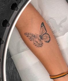 a woman's arm with a butterfly tattoo on it