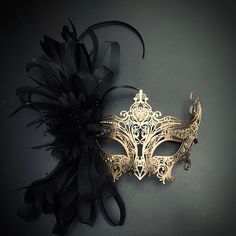 Feathers and floral complement the fashionable apparatus - the gold metal mask - to any function. Masquerade Dress And Mask, Mask Ball Party, Black And Gold Masquerade Mask, Extravagant Dresses, Masquerade Mask Women, Gold Masquerade Mask, Mask Ball, Floral Mask, Mask Men