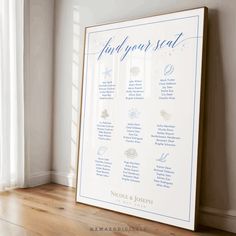 a wedding seating chart is displayed in front of a window with white curtains and wood flooring