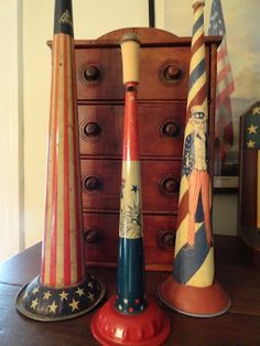 three patriotic candlesticks sitting on top of a wooden table