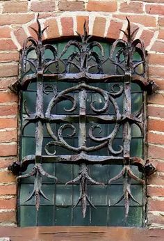 an old iron window on the side of a brick building