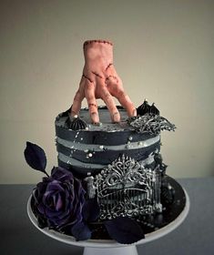 there is a cake decorated with black and silver decorations