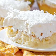 a piece of cake with white frosting on top sitting on a plate next to a yellow napkin