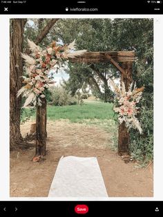 the wedding arch is decorated with flowers and greenery, along with a white aisle